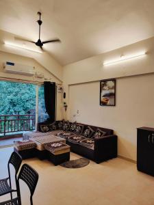 a living room with a couch and a table at Mountainview Paradise - Cozy 1bhk amidst mountains in Karjat +29 photos