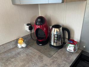 a kitchen counter with a coffee maker and a tea kettle at Panacci Van - Weymouth Bay in Preston +10 photos