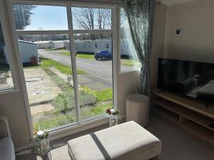 a living room with a large window and a television at Panacci Van - Weymouth Bay in Preston
