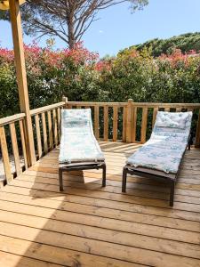 two chairs sitting on a wooden deck at Mobil Home - 3CH - 2 SDB - Clim - Wifi in Roquebrune-sur-Argens