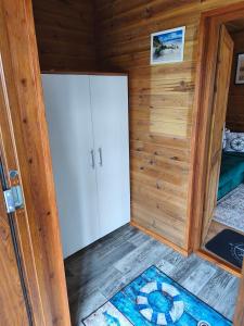 a small room with a white door and a rug at Domek Słoneczny nad morzem in Kąty Rybackie