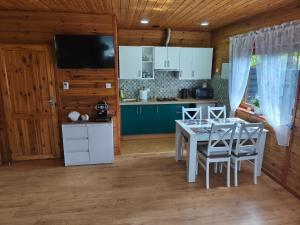a kitchen and dining room with a table and chairs at Domek Słoneczny nad morzem in Kąty Rybackie