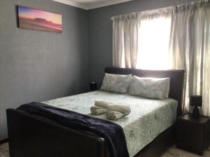 a bedroom with a bed with two shoes on it at Private Secure house in Alberton in Alberton
