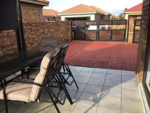 a patio with a table and chairs and a fence at Private Secure house in Alberton in Alberton