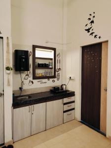 a kitchen with a sink and a mirror on the wall at Mountainview Paradise - Cozy 1bhk amidst mountains in Karjat