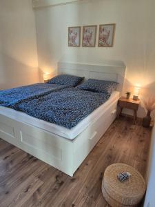 a bedroom with a large bed with blue sheets at Balatoni Horizont Vendégház in Balatonakarattya