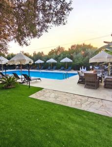 a pool with chairs and tables and umbrellas at Kibele Hotel in Oludeniz