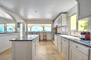 a kitchen with white cabinets and black counter tops at villa coralia - panoramic view in Saint Martin