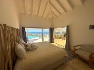 a bedroom with a bed and a view of the ocean at villa coralia - panoramic view in Saint Martin +11 photos