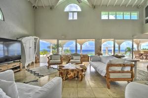 a large living room with white couches and a table at villa coralia - panoramic view in Saint Martin