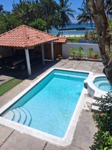 a swimming pool with an umbrella in a yard at Villa Lya in Juan Dolio