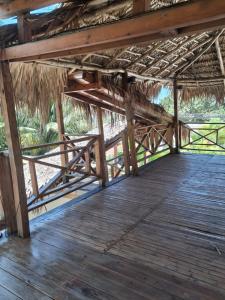 a wooden deck with a thatched roof at Villa Lya in Juan Dolio