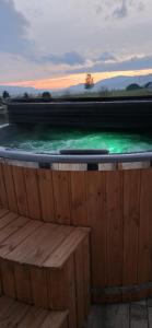 a pool of green water with a wooden deck at Farma HUGÁNIKOVO - families, pets & spa relaxation in Brezno