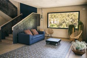 a living room with a blue couch and a window at Can Alemany in Santa Margarita de Mombúy