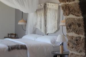 a bedroom with two beds with white sheets and two lamps at Can Alemany in Santa Margarita de Mombúy
