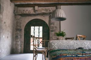 a dining room with a table and chairs and a window at Can Alemany in Santa Margarita de Mombúy