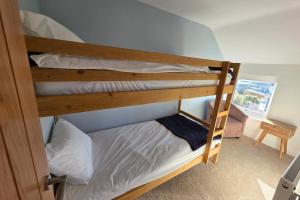 a couple of bunk beds in a room at Coastal Cottage NC500 in Castletown