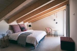 a bedroom with a large bed with a wooden ceiling at Can Alemany in Santa Margarita de Mombúy