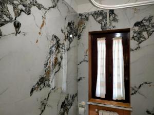a bathroom with black and white marble walls and a window at casa vacanze Libeccio parcheggio privato in Sapri