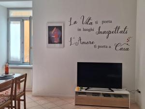 a living room with a tv and a wall at Mi'Ele Apartments in Pergine Valsugana