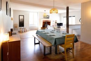 a dining room and living room with a table and chairs at Moulin XVe siècle - Gîte privatif 8 pers - Rivière - Châteaux de la Loire in Vineuil