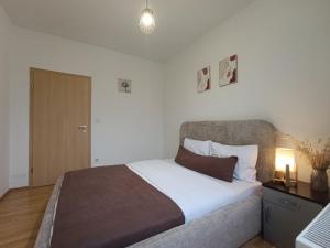 a bedroom with a large bed and a lamp on a table at Aria Apartment in Prishtinë +50 photos