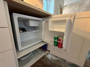 an empty refrigerator with its door open in a kitchen at Viesu māja Gulbji in Bigauņciems