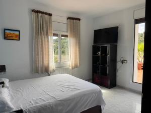 a bedroom with a bed and a flat screen tv at Villa Maria Mercedes in Olesa de Bonesvalls +26 photos