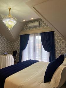 a bedroom with a bed and a chandelier and a window at Chalés e suítes vila verde in São Bento do Sul