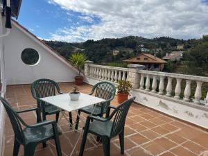 a patio with a table and chairs on a balcony at Villa Maria Mercedes in Olesa de Bonesvalls