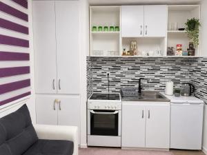 a kitchen with white cabinets and a stove top oven at Stan na dan Bosanska Krupa in Bosanska Krupa