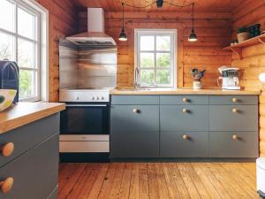 a kitchen with blue cabinets and a stove at 4 person holiday home in Assens in Assens