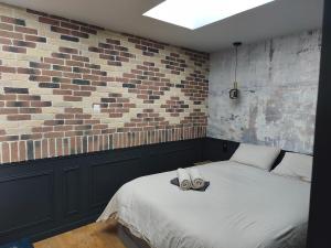 a bedroom with a bed and a brick wall at Escale à Clisson - l'Hippo Loft in Clisson