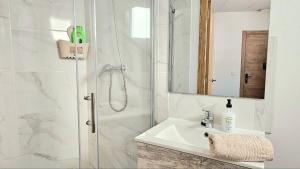 a white bathroom with a sink and a shower at Golden Tower Rooms - auto check-in in Gandía