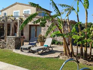 two lounge chairs in front of a house at La Sorteta De Cuxach in Pollença