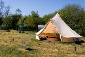 a tent is set up in a field at Battle Pods and Bells Glamping in Battle