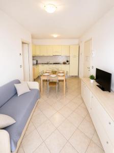 a living room with a couch and a table at RESIDENCE STEFANIA - AGENZIA COCAL in Caorle +5 photos