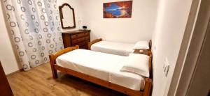a small bedroom with two beds and a mirror at sunset suite con terrazza e barbecue in Imperia