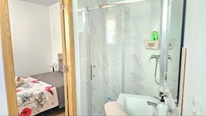 a bathroom with a shower with a tub and a sink at Golden Tower Rooms - auto check-in in Gandía