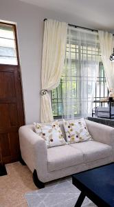 a living room with a couch and a window at Rosewood Cozy homes in Mbeya +4 photos