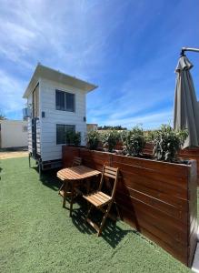 a patio with a table and an umbrella and a house at Nómada Hostel in El Palmar