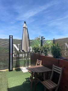 a patio with an umbrella and a chair and a table at Nómada Hostel in El Palmar