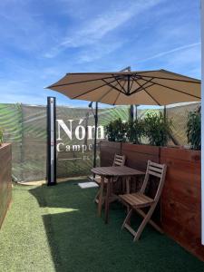 a wooden table and chairs under an umbrella at Nómada Hostel in El Palmar +28 photos
