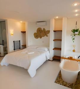 a bedroom with a white bed and a bath tub at Artha Home Spa in Governador Celso Ramos +44 photos