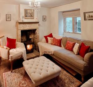 a living room with a couch and a fireplace at Four bedroomed 18th century cosy cottage three miles from Bath City Centre in Batheaston