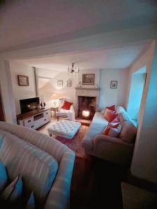 a living room with a couch and a fireplace at Four bedroomed 18th century cosy cottage three miles from Bath City Centre in Batheaston +27 photos
