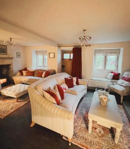 a living room with a couch and a table at Four bedroomed 18th century cosy cottage three miles from Bath City Centre in Batheaston