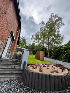 a flower bed in front of a building at Villa bel horizon avec jacuzzi in Hotton