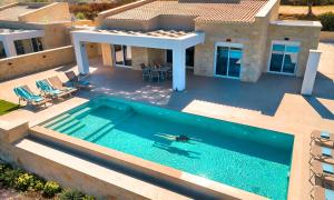 an aerial view of a house with a swimming pool at Marea Villas Heated Pool in Dhrámia