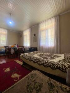 a bedroom with two beds and a dining room with a table at Mta House Racha in K'veda Shavra